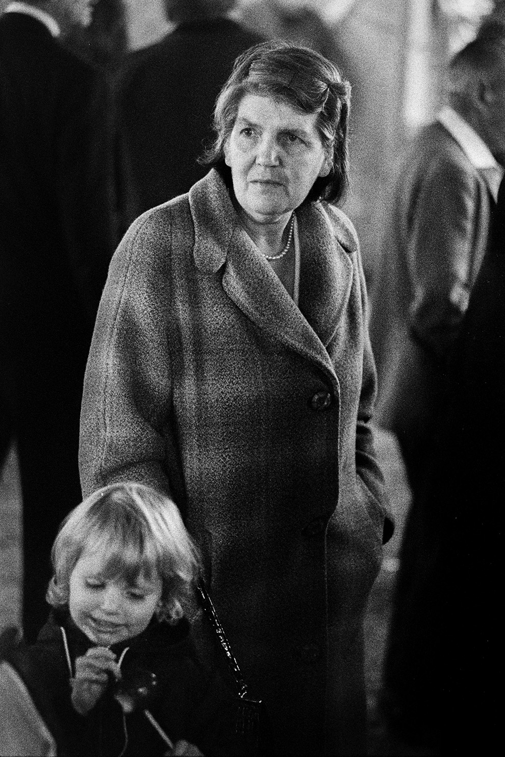 A woman and child at Barnstaple Fair. The child is holding a toffee apple.