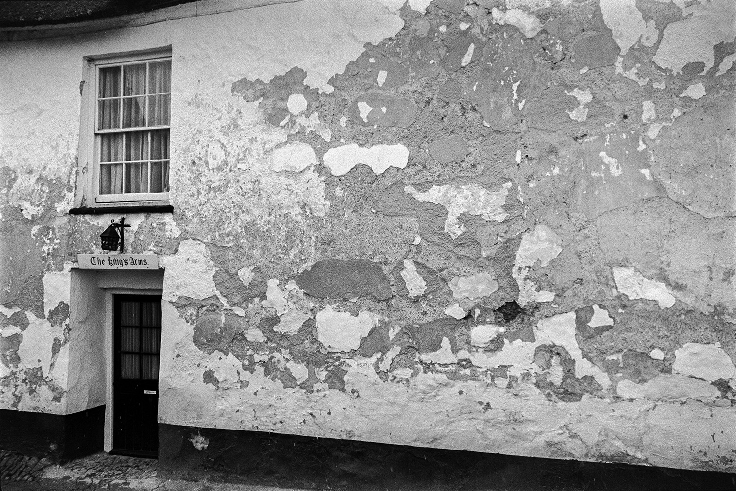 An entrance to The Kings Arms pub in Winkleigh. The render is peeling off the walls.