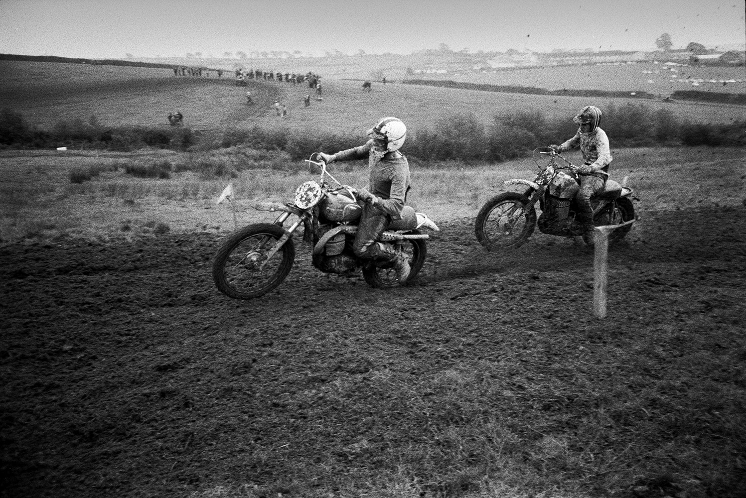 Competitors racing along a muddy course at Torrington motorbike scramble.