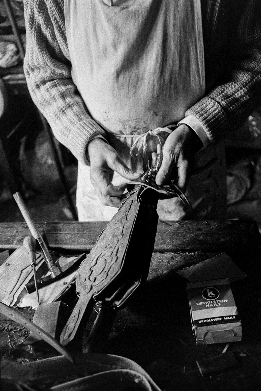 Derek Johns working on a small pair of bellows in his saddlery workshop in Bideford.