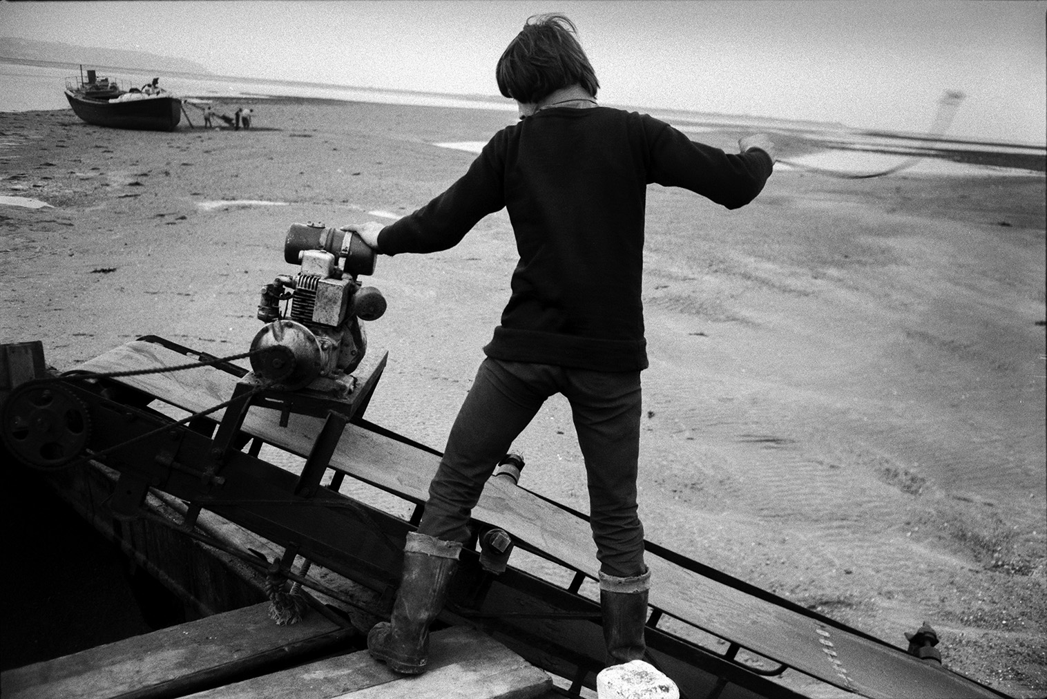 A man starting a conveyor belt or elevator on a sand barge at Crow Point, Braunton. Another barge can be seen in the background.