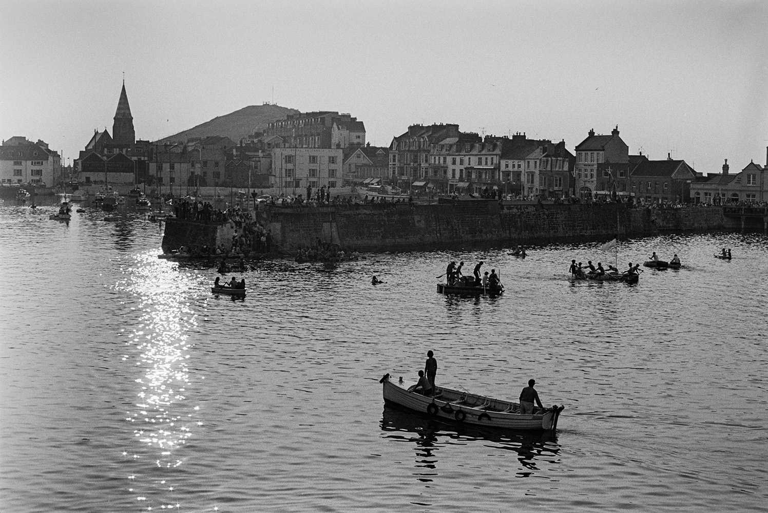 Spectators watching the raft race from the harbour wall at Ilfracombe. The town can be seen in the background.