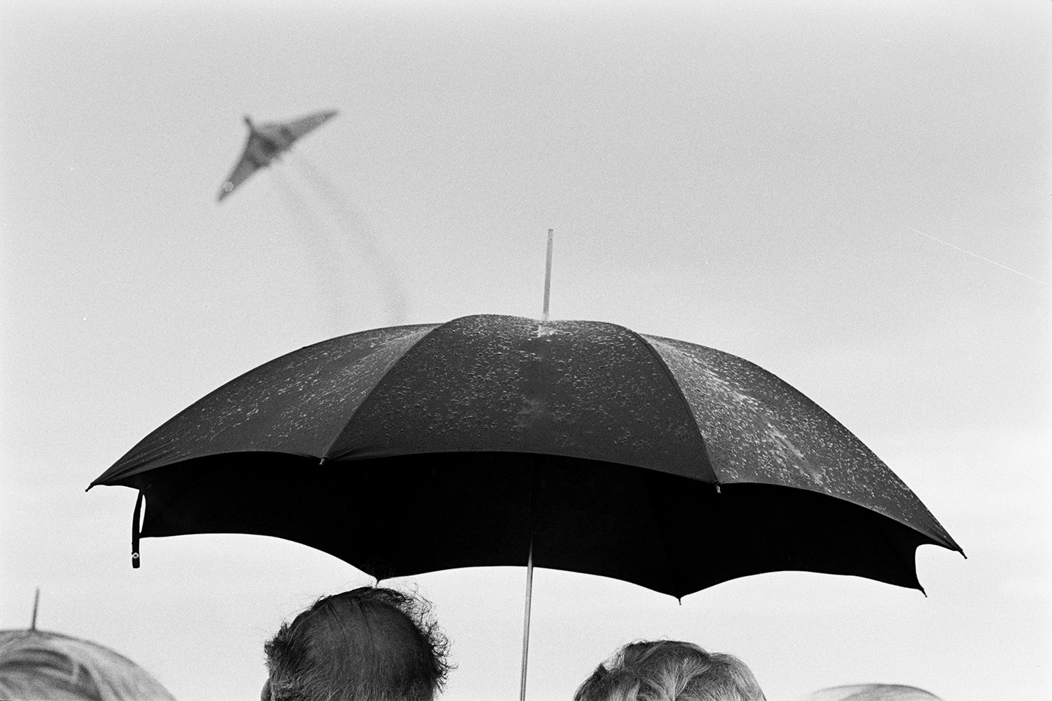 Spectators holding umbrellas watching an air craft display at Chivenor Air Show at the Royal Marine Base in Braunton.