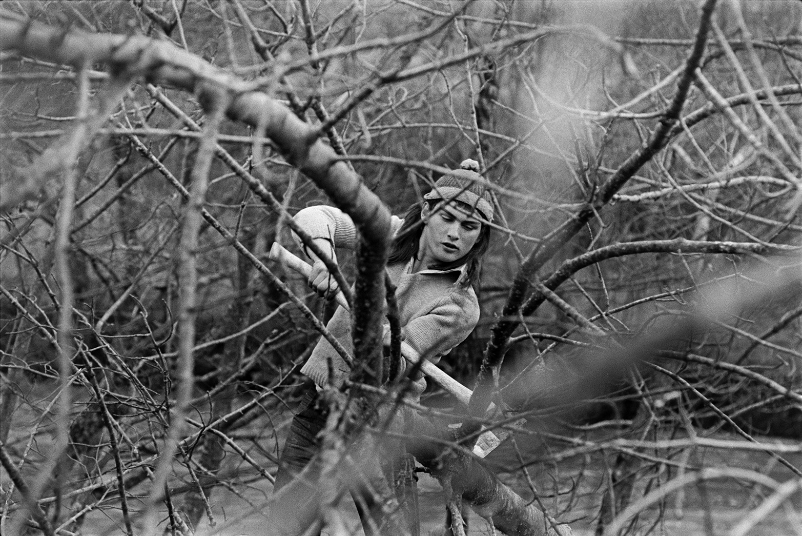 Derek Bright using an axe to cut branches off trees by the River Torridge in a field at Mill Road Farm, near Beaford Bridge. The farm was also known as Jeffrys.
