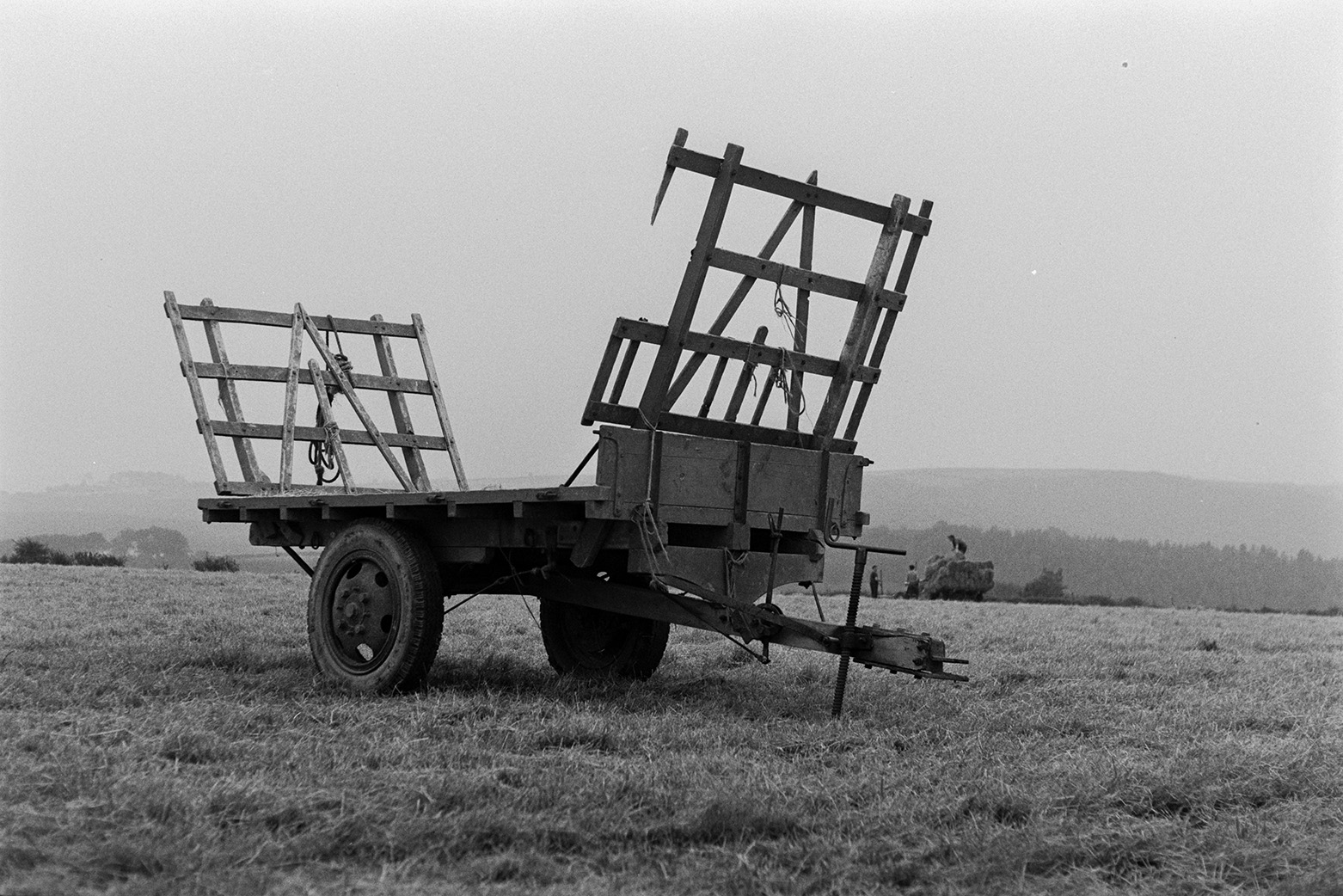 Empty trailer in a field at Mill Road Farm, Beaford. Another trailer is being loaded with hay bales in the background. The farm was also known as Jeffrys.