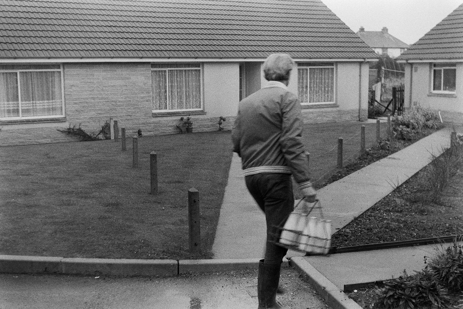 Ivor Bourne delivering milk bottles to a bungalow in Beaford.