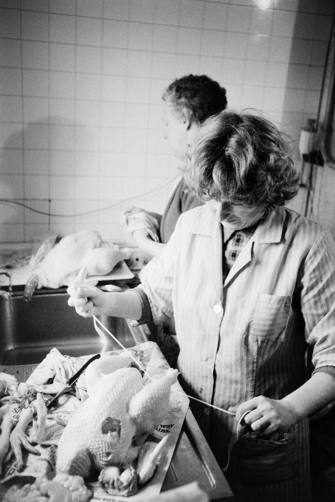 Marylin Bourne and another woman preparing Christmas chickens in the kitchen at Mill Road Farm, Beaford. The farm was also known as Jeffrys.