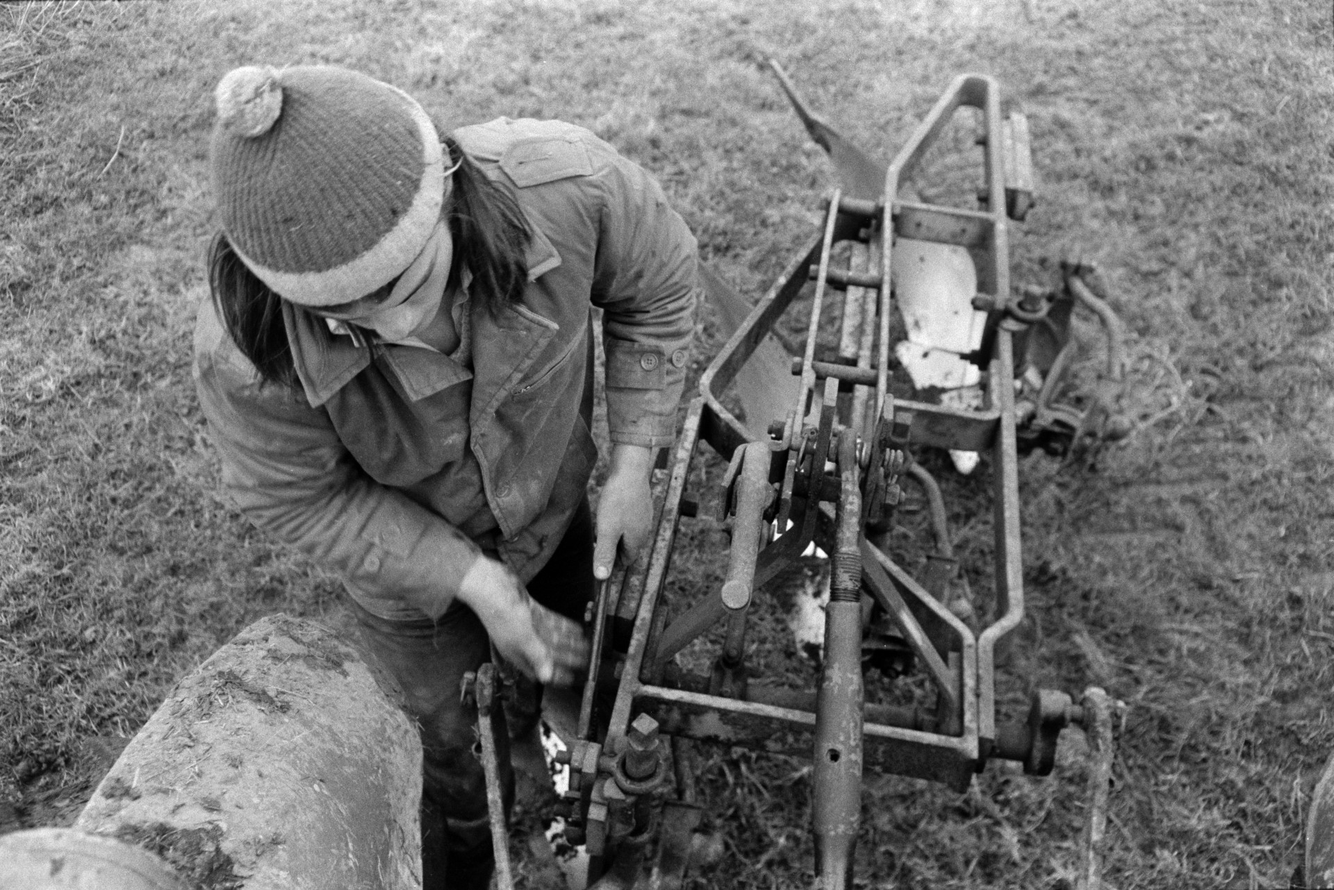 Derek Bright looking at the mechanics of a plough because it was not furrowing evenly, in a field at Mill Road Farm, Beaford. The farm was also known as Jeffrys.