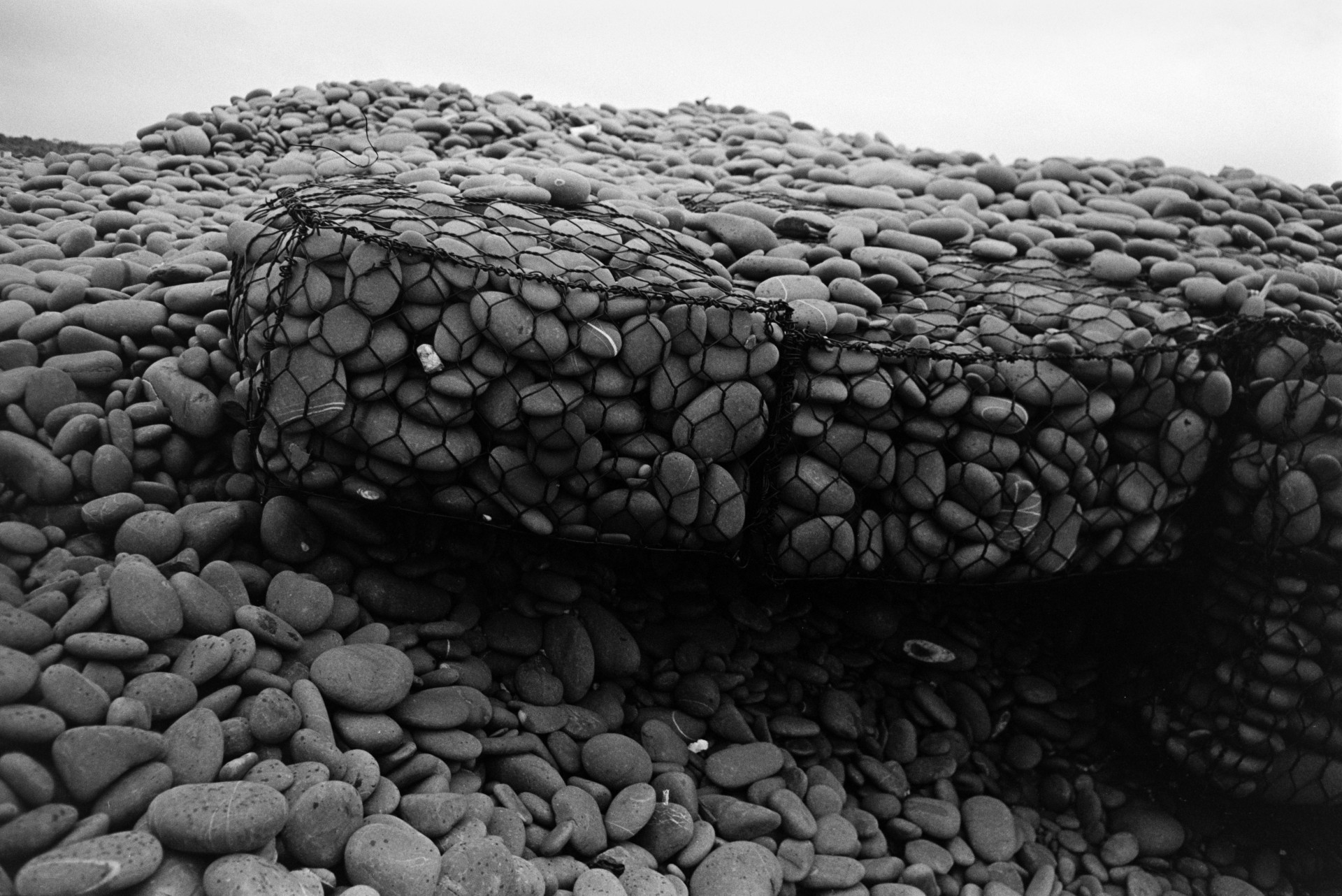 a sea defence of pebbles in a wire cage on the pebble beach at Westward Ho!