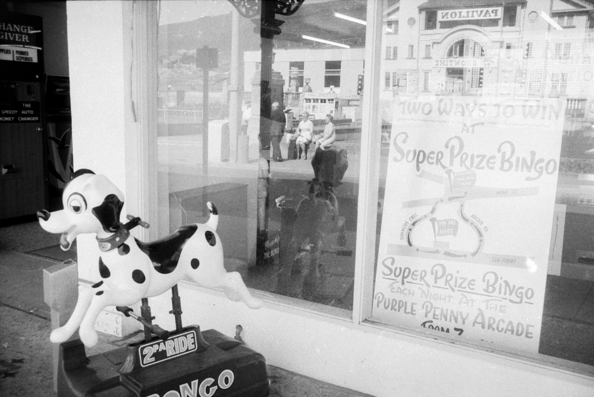 A children's coin operated ride in the shape of a Dalmatian outside a shop front at Ilfracombe. An advert for Bingo is in the shop window.