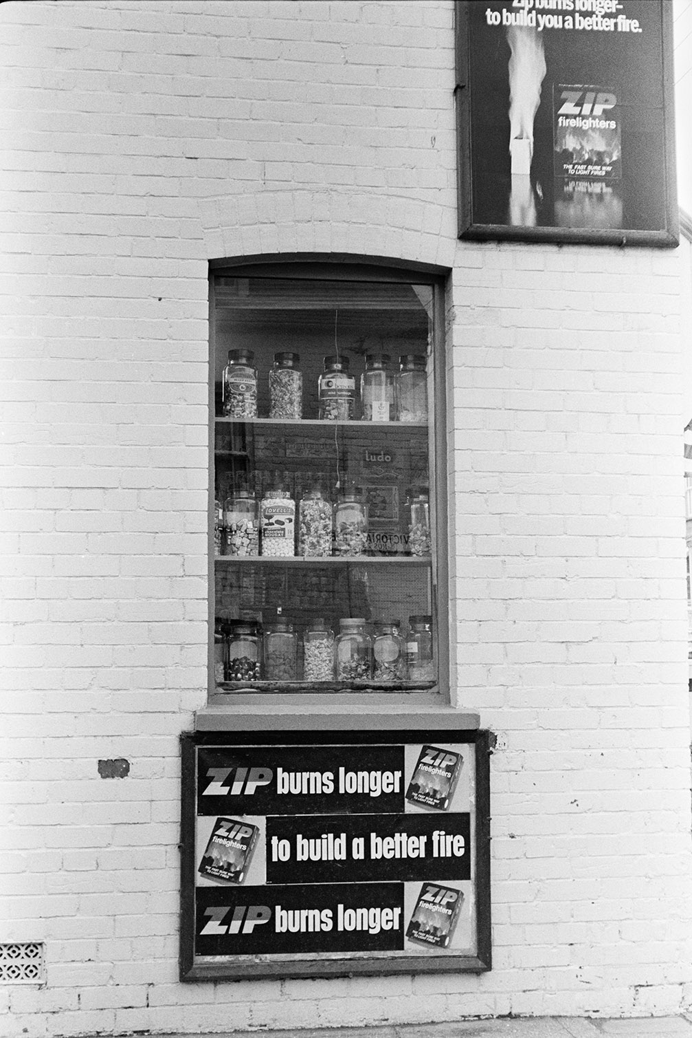 Advertising boards for Zip firelighters outside a shop window with sweet jars, in Barnstaple.