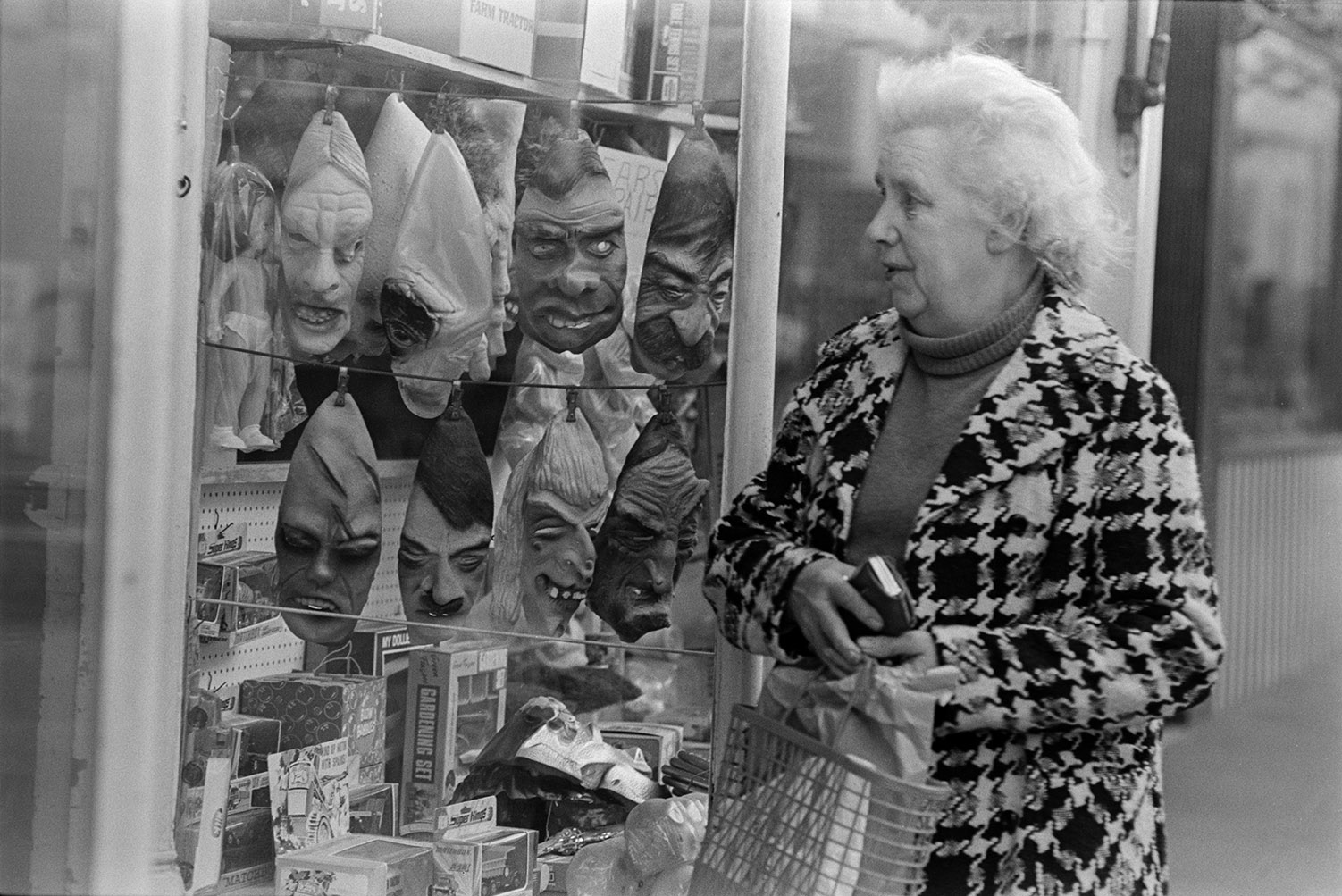 A woman looking at masks on display, in a shop front window in Barnstaple.