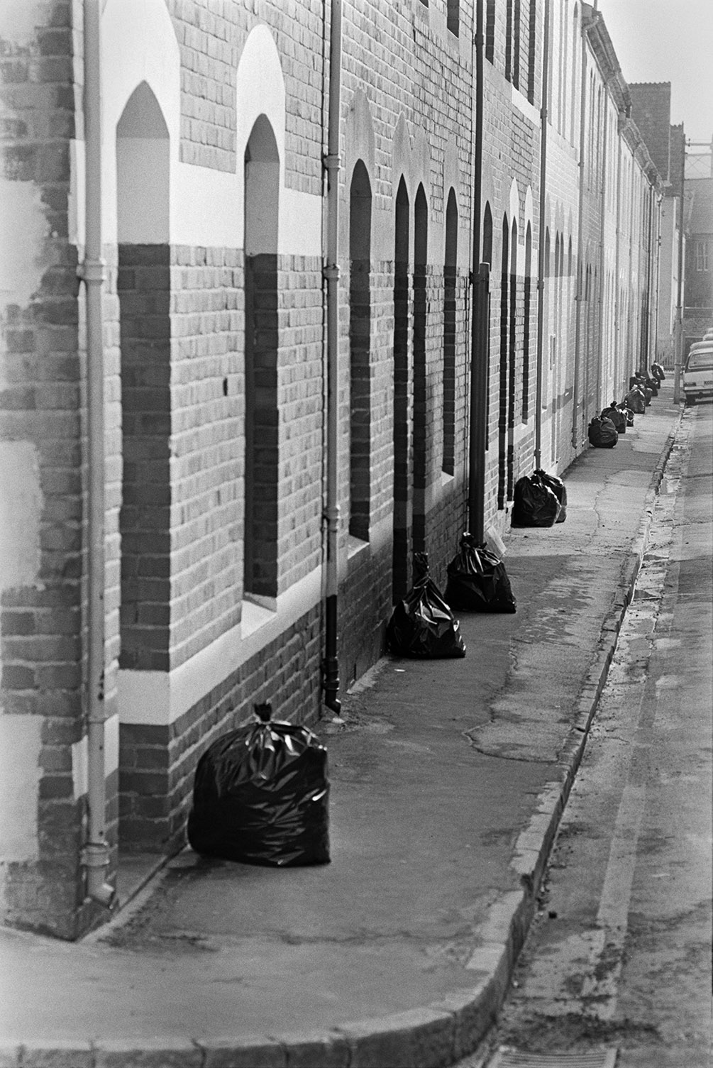 A street in Barnstaple with rubbish bags waiting to be collected.