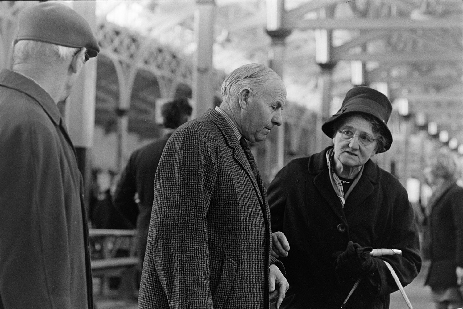 Two men and a woman talking at Barnstaple Pannier Market.