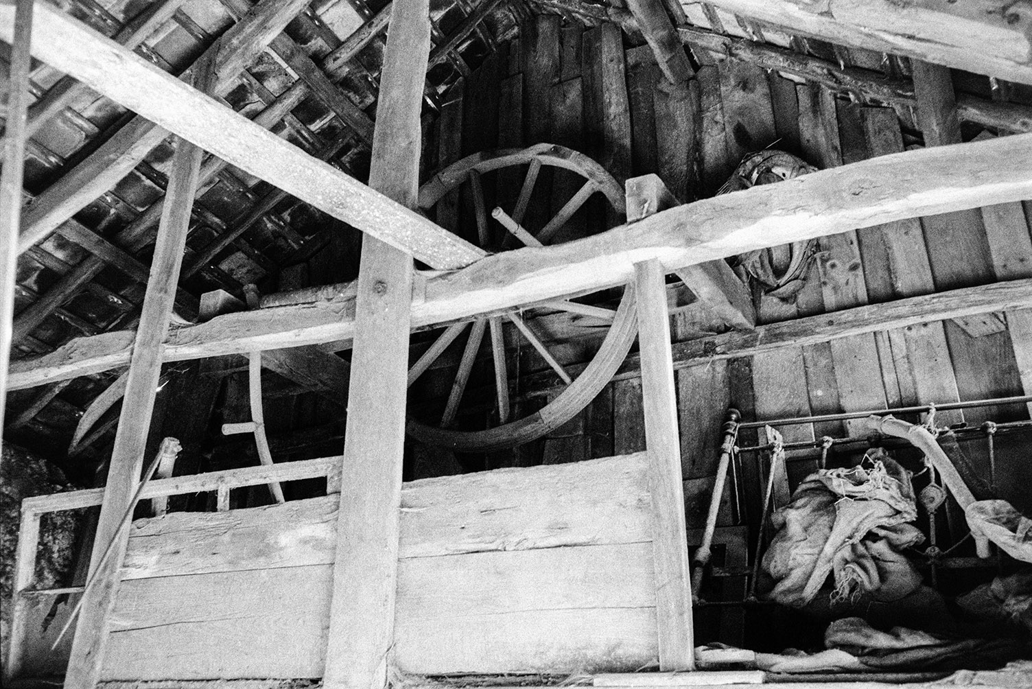A wooden barn with a large wooden wheel at Kigscott.