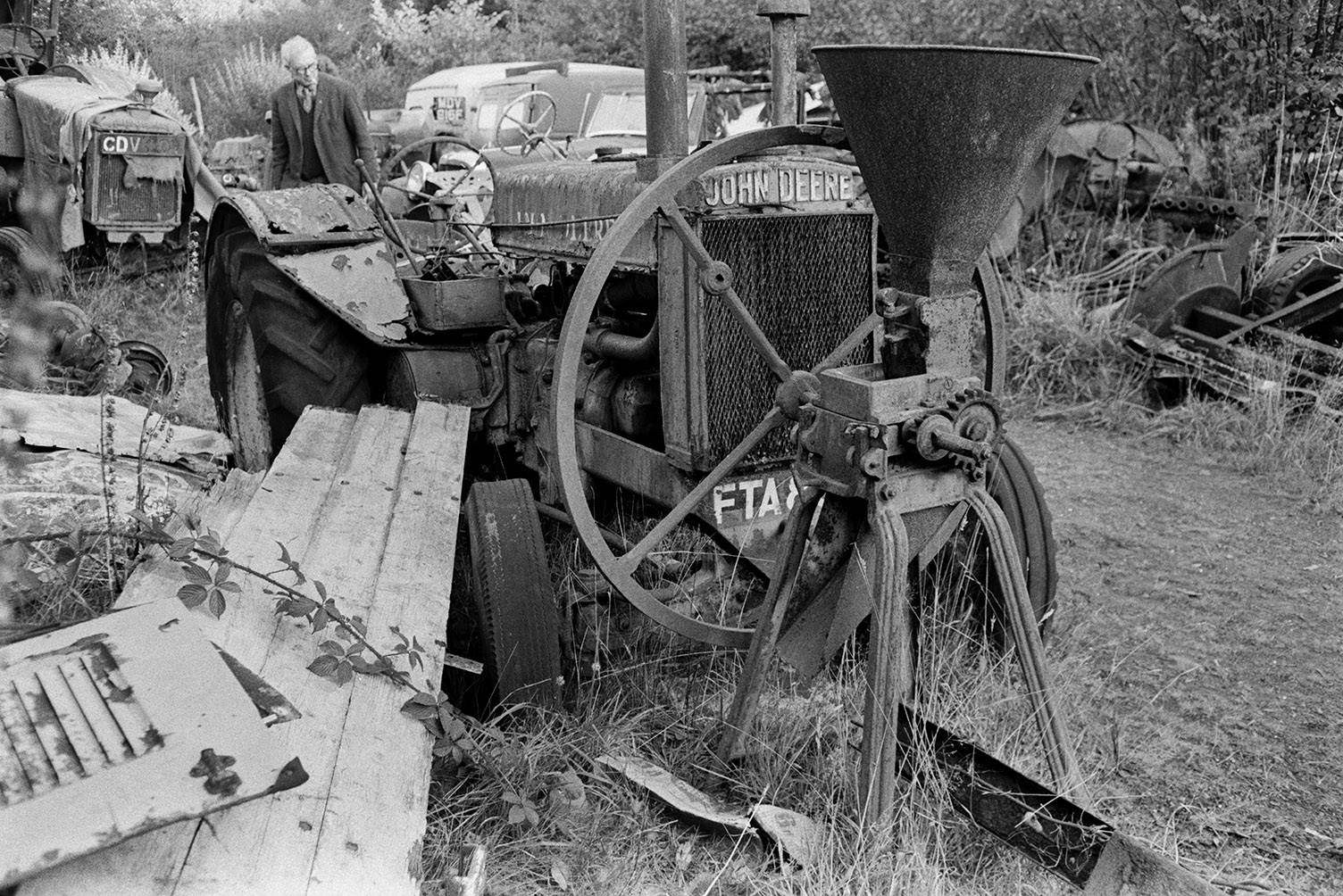 Mr Weeks looking at old farm machinery including a John Deer tractor and old vans, in a reclamation yard at Umberleigh.
