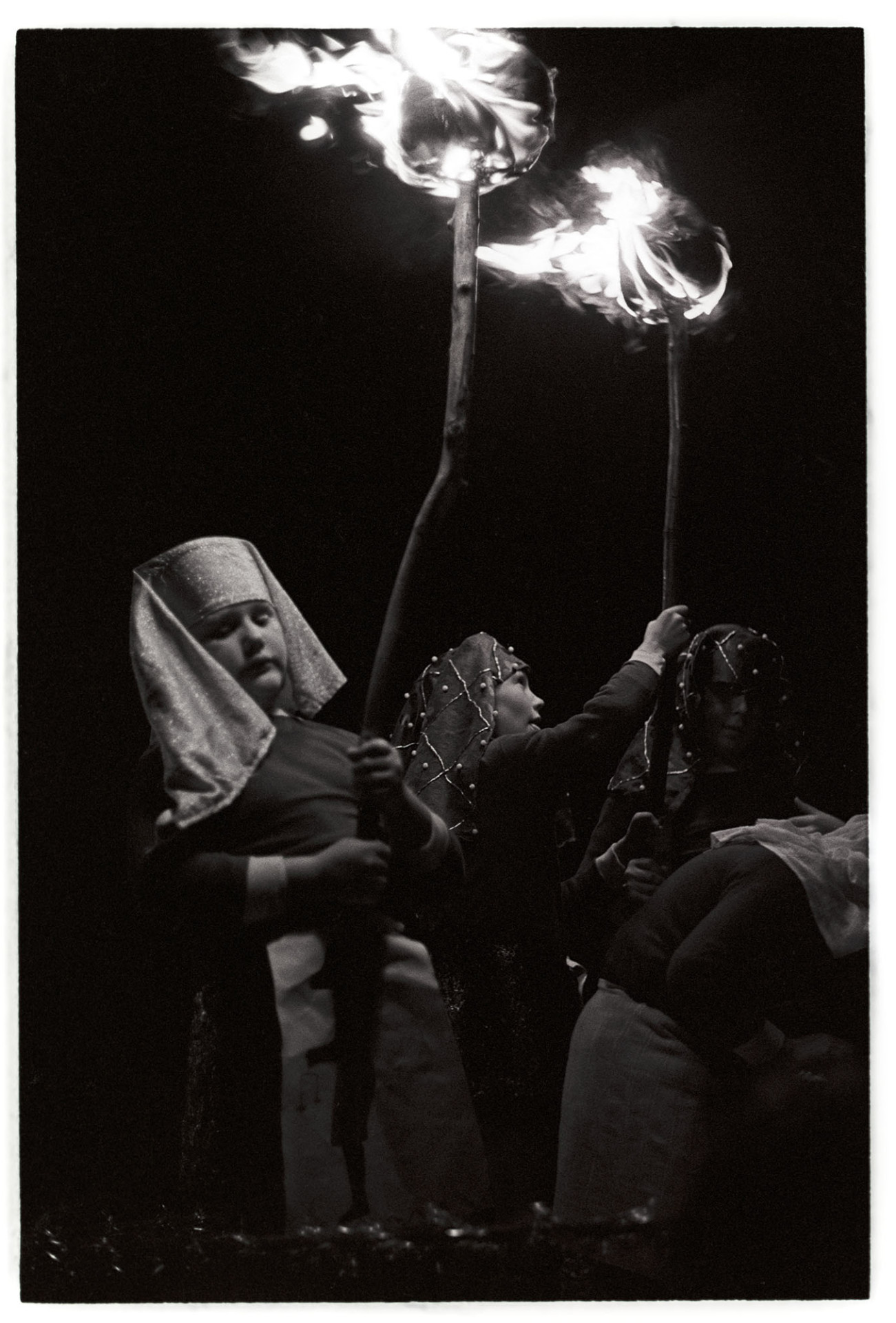 Boys with flaming torches at night.
[Children carrying flaming torches with the 'Tutankhamun' carnival float at Dolton Carnival.]