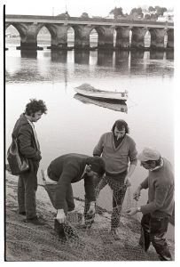Salmon fishermen mending nets by James Ravilious