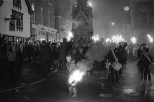 Boy with blazing torch at the start of night time procession by James Ravilious