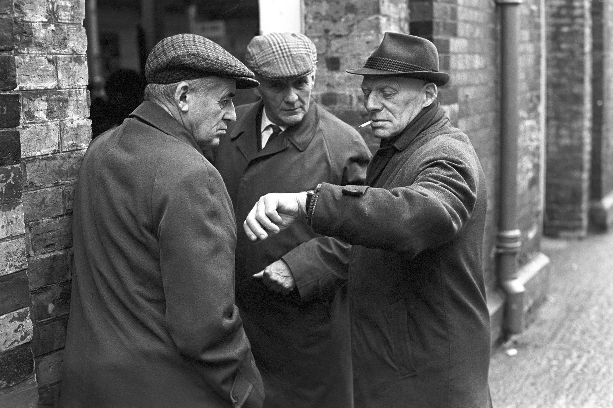 Men chatting outside the Pannier Market by James Ravilious