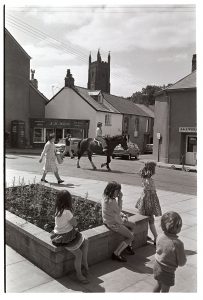 Children sitting in town by James Ravilious