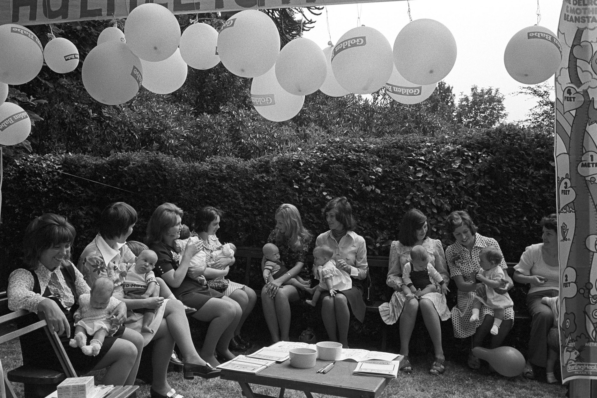 Church Garden Party, mothers and babies at baby show, balloons.
[Mothers and babies seated beneath balloons at the Chulmleigh Church Garden Party baby show in the grounds of Chulmleigh Vicarage.]