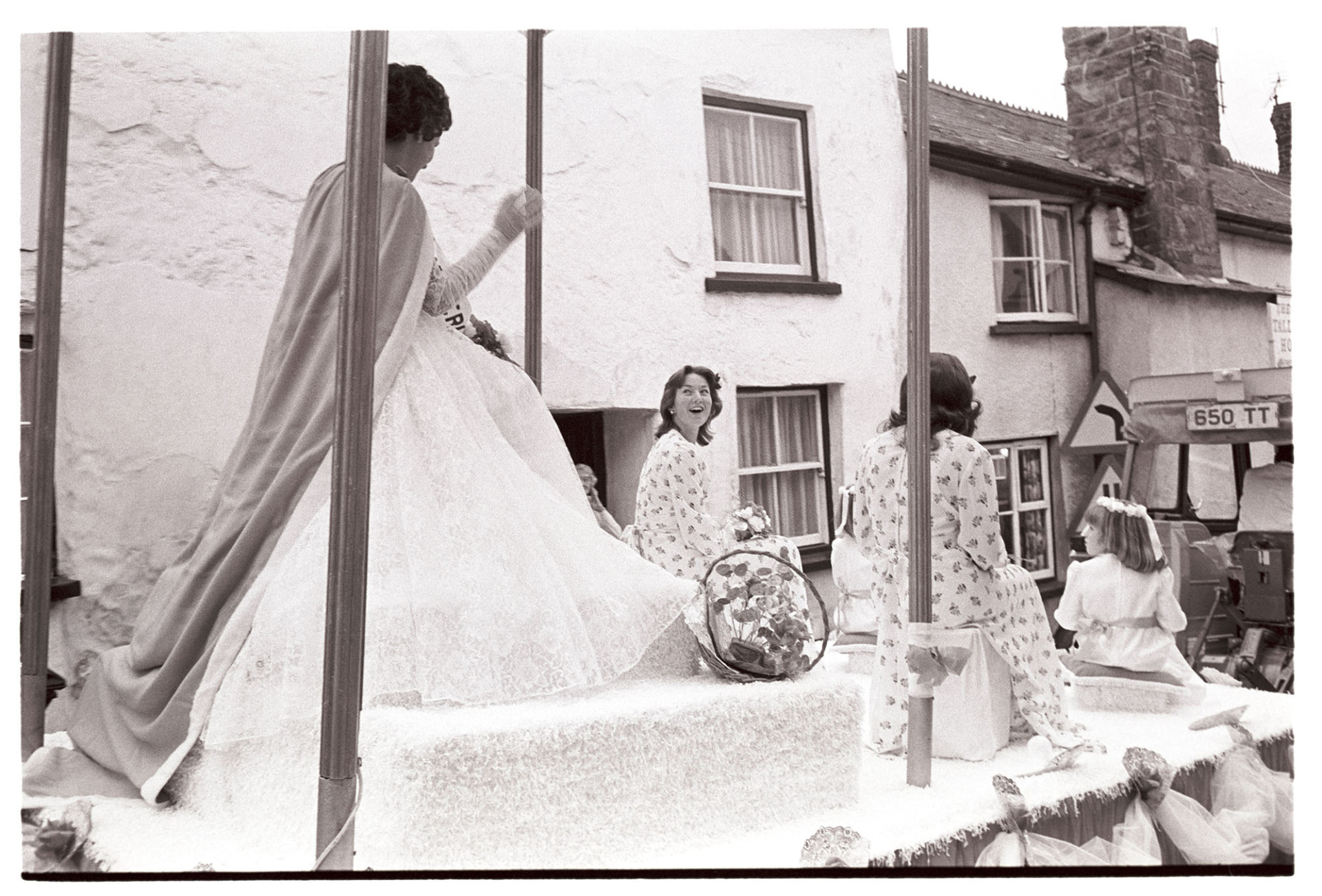 Carnival Queen and attendants on float during parade.
[Sue Reynolds, Carnival Queen, with her attendants on a carnival float being pulled by a tractor at Hatherleigh Carnival.]
