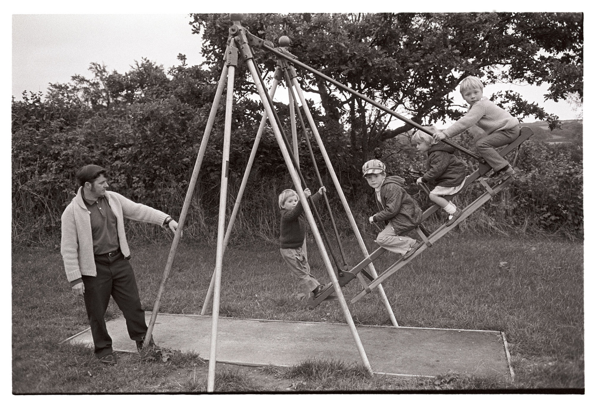 Children on new playground swings.
[A man pushing four children on new playground swings at Dolton Playing Fields.]