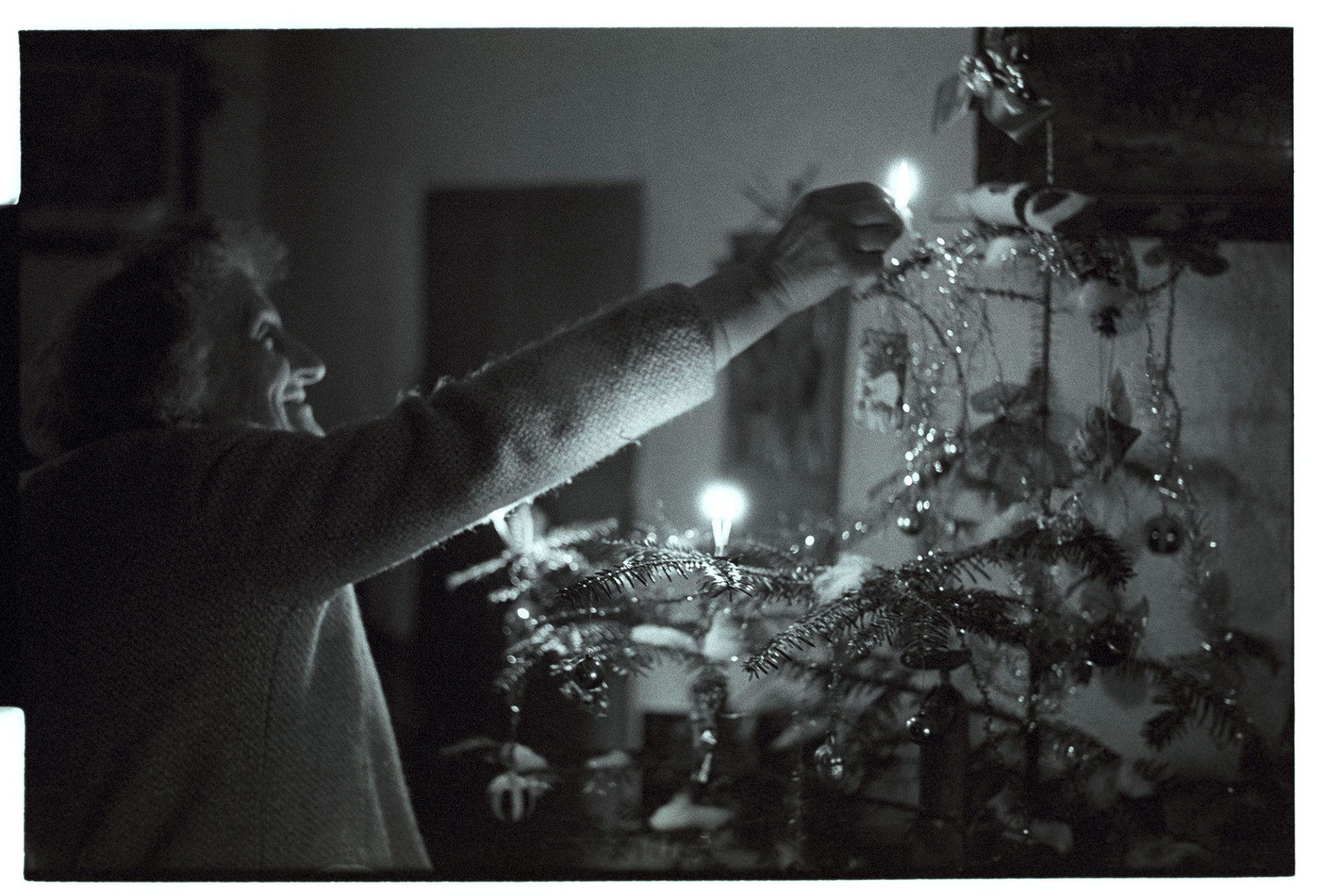 Woman lighting candles on Christmas Tree.
[Jean Pickard lighting candles on a Christmas tree at Woolridge, Dolton]