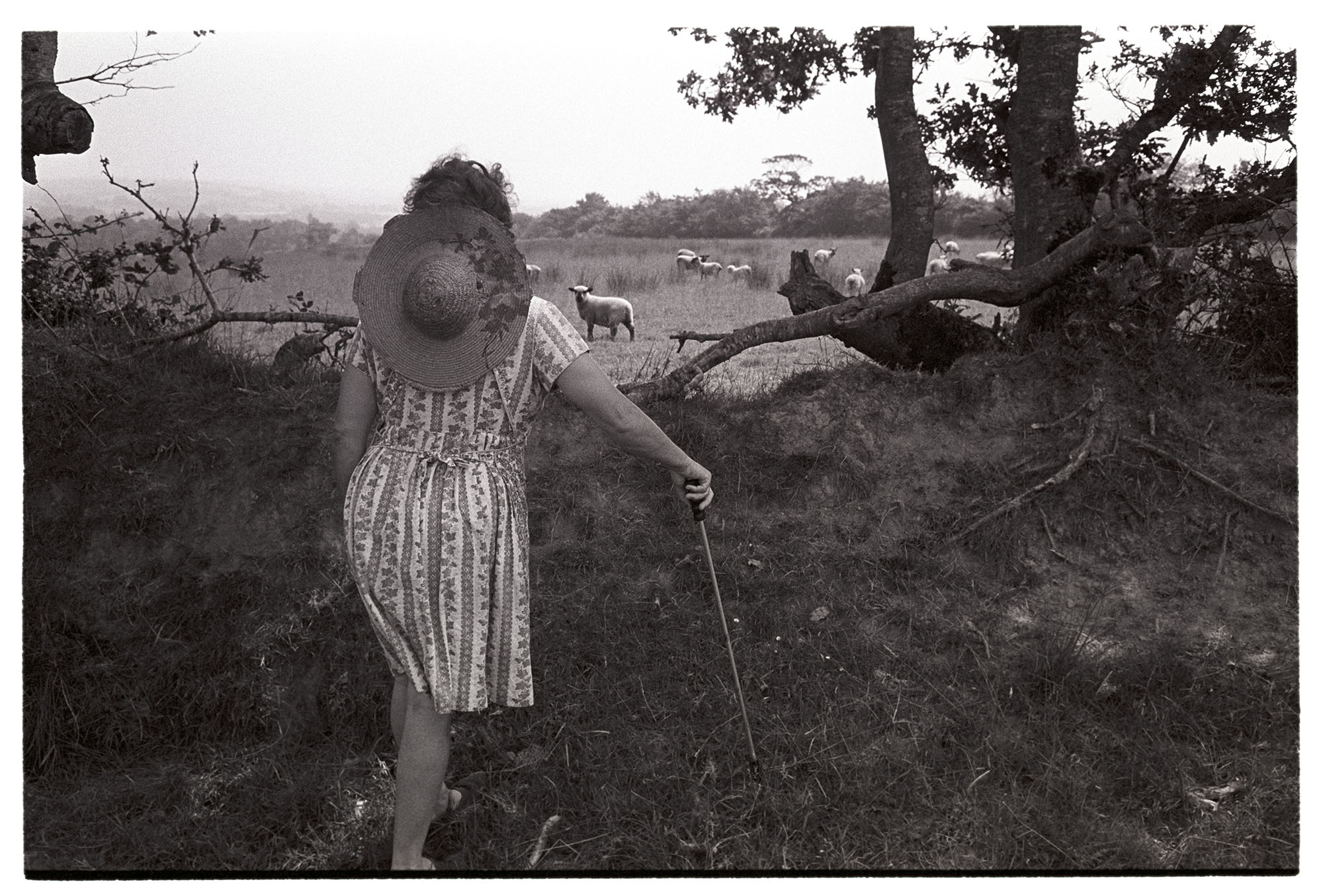 Woman in black and white hat holding black and white stick photo