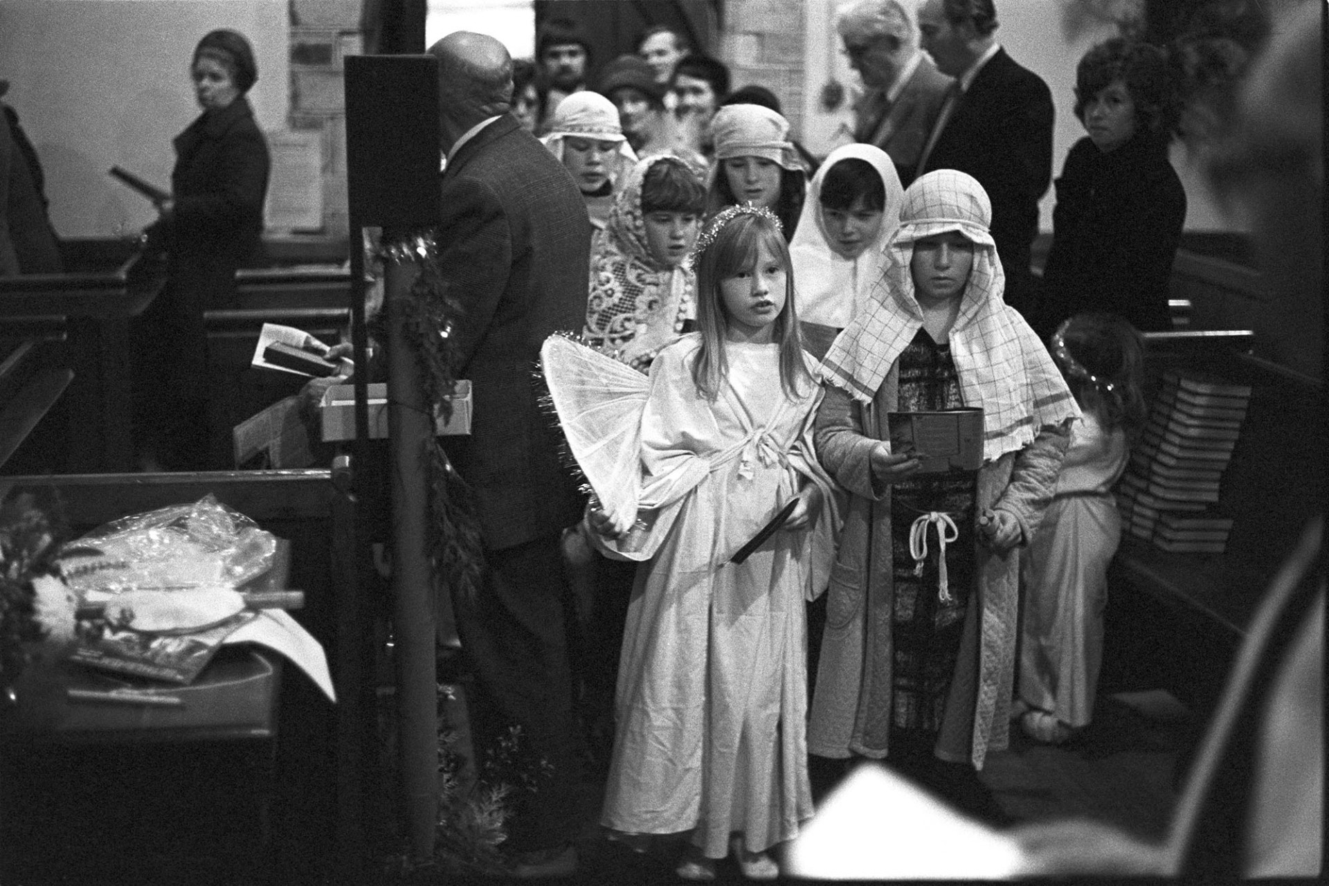 Nativity play, children in procession into church.
[Children processing into Dolton Church for a nativity play and service.  A girl is dressed as an angel and other children are dressed as shepherds. Members of the congregation are watching them.]