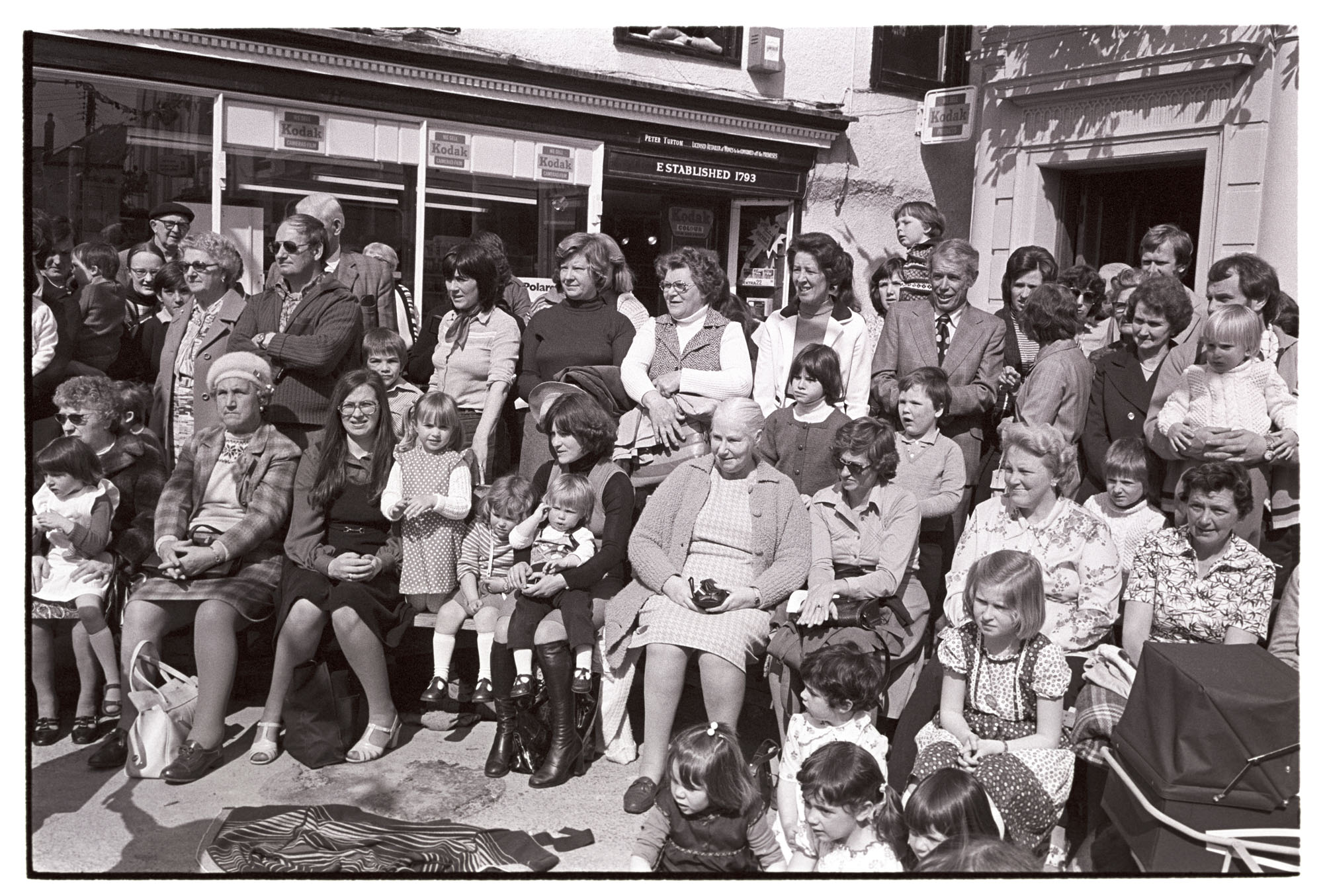 Crowds watching Mayfair, town square. <br />
[Spectators watching the Mayfair parade in Torrington town square.]