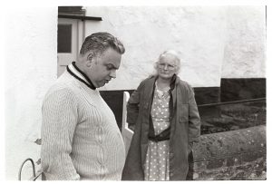 Tommy Isaacs and his mother listening to Peter Mills MP by James Ravilious