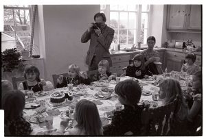 Roger Hill taking photos at children's birthday party by James Ravilious