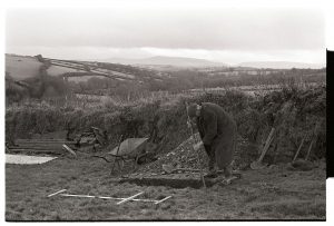 Man digging a grave by James Ravilious