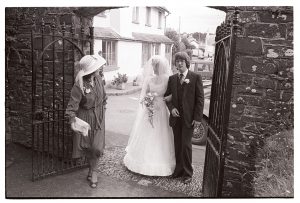 Bride and best man arriving at Dolton Church by James Ravilious