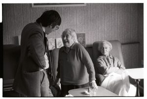 Dr Paul Bangay talking to a patient in the day room by James Ravilious