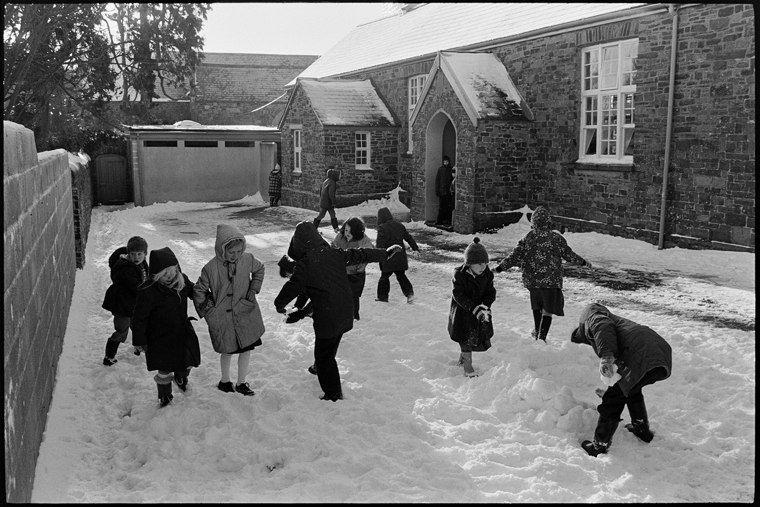 Children playing in snow in school playground. 
[School children playing in the snow in the playground at Dolton Primary School.]