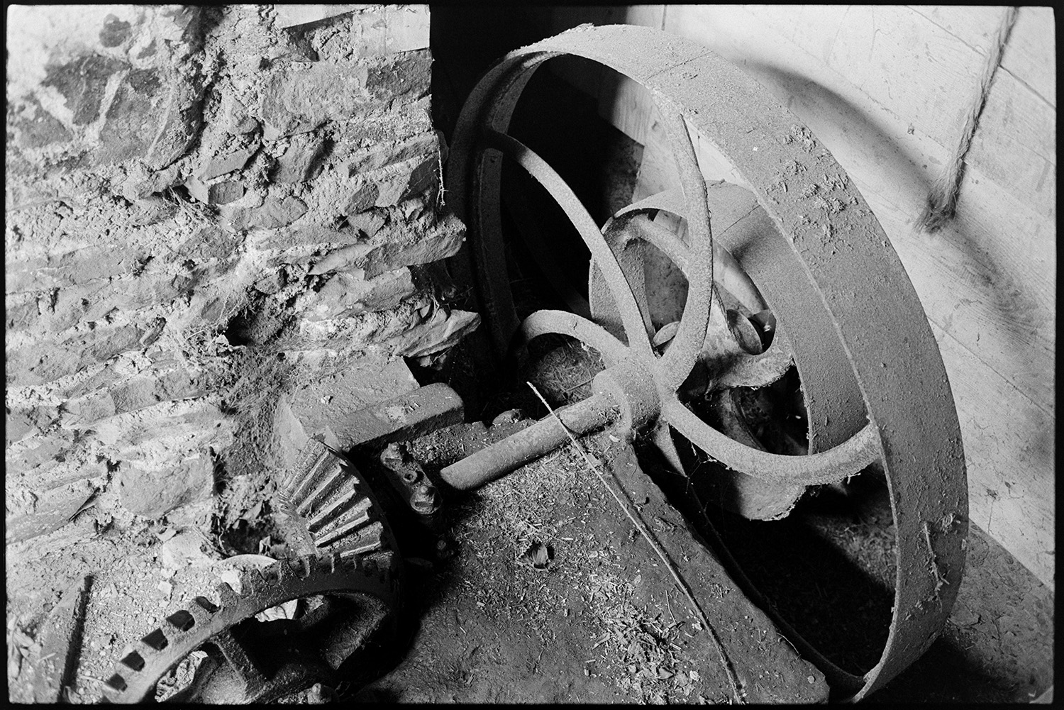 Pulley wheels and cogs of mill undershot construction.
[Pulley wheels and the cogs of an old mill undershot construction section at West Chapple Farm near Winkleigh.]