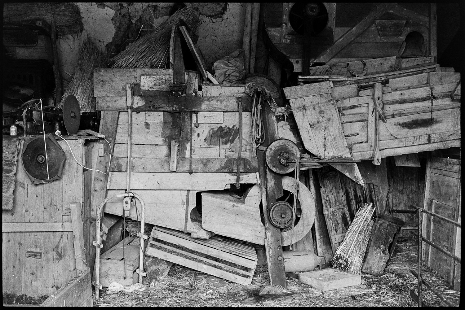 Barn thresher, threshing machine.
[Old wooden threshing machine in a barn at West Chapple Farm, near Winkleigh.]