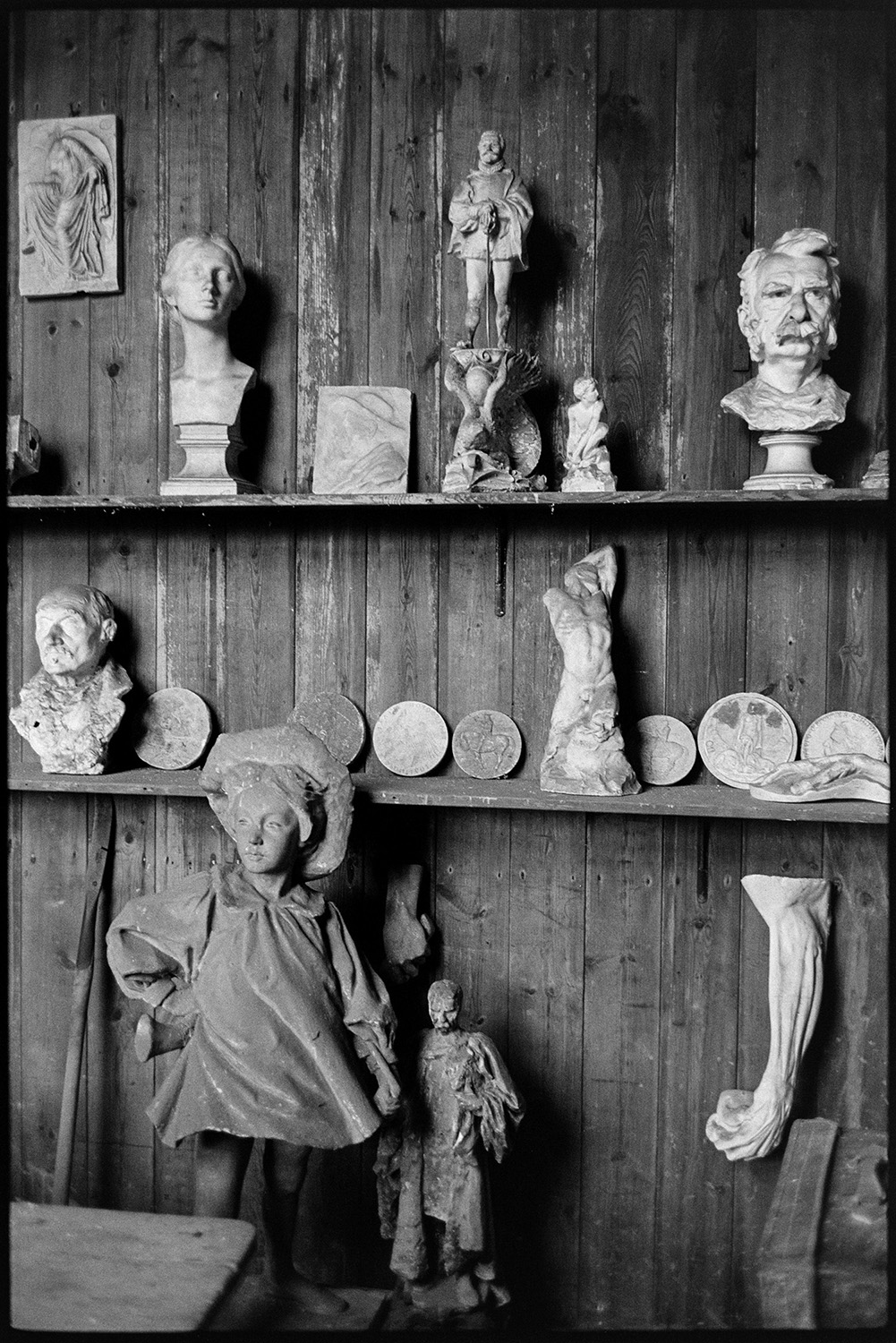 Sculpture casts on shelf in workshop, formerly sculptors studio.<br />
[Sculpture casts displayed on shelves in a workshop, formerly the sculptor's studio belonging to John Henry Furse (father of Sir Ralph Furse), at Halsdon House near Dolton. Busts and figurines are visible.]