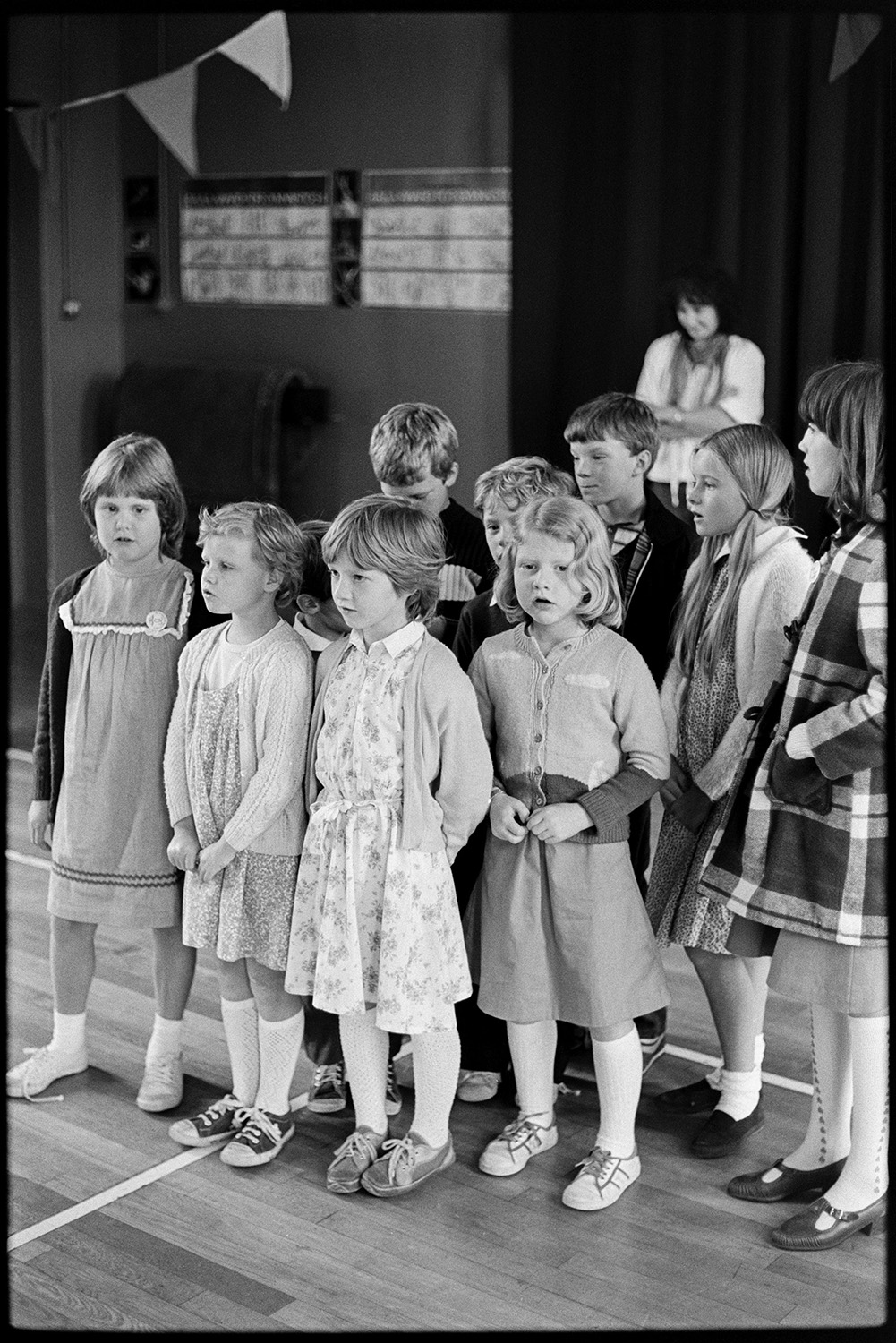 Schoolchildren singing, dancing with folk duo. 
[A group of children singing in a folk workshop at Barnstaple, run by the folk duo Sam Richards and Tish Richards.]
