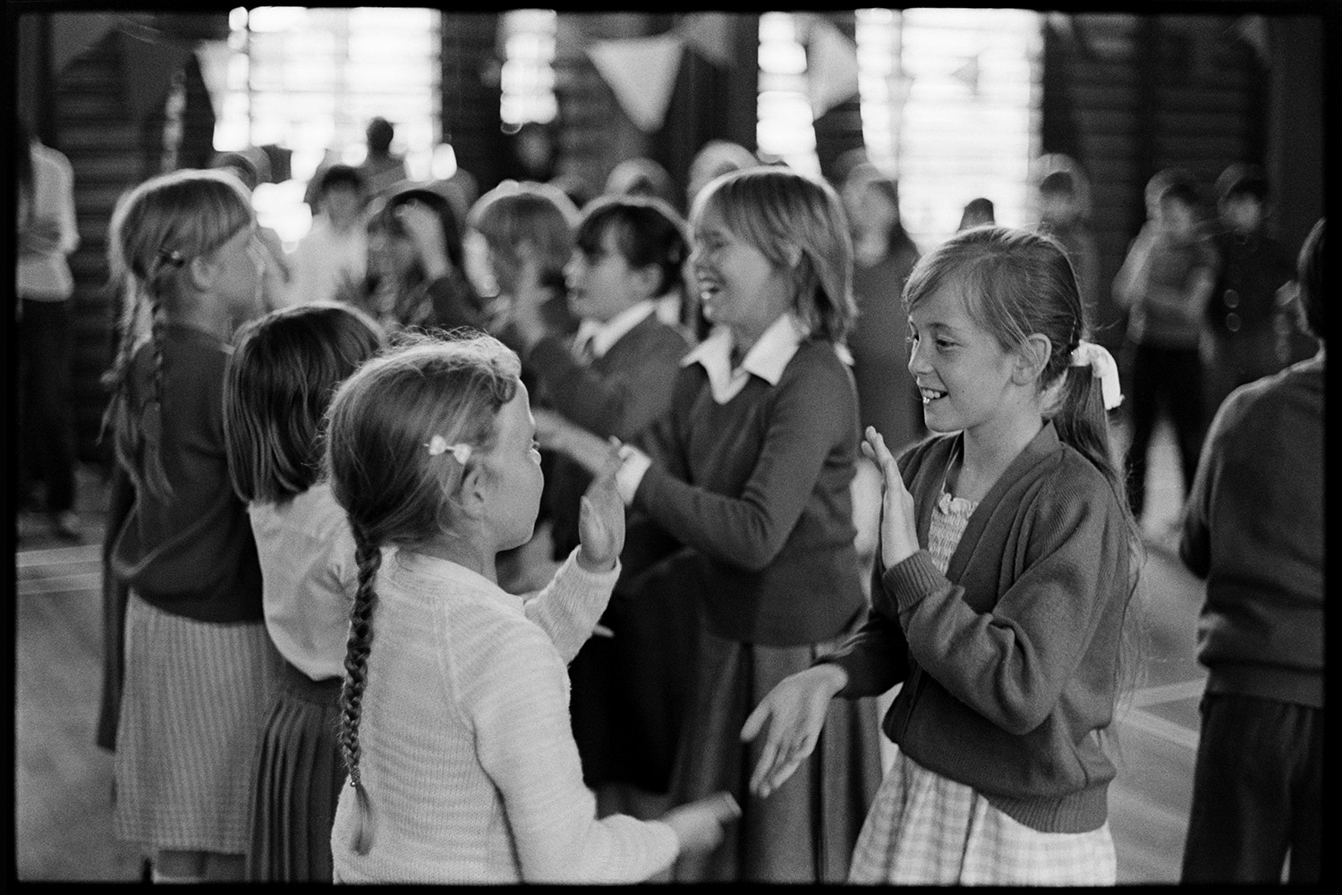 Schoolchildren singing and playing a clapping game in a folk workshop at Barnstaple, run by the folk duo Sam Richards and Tish Richards.