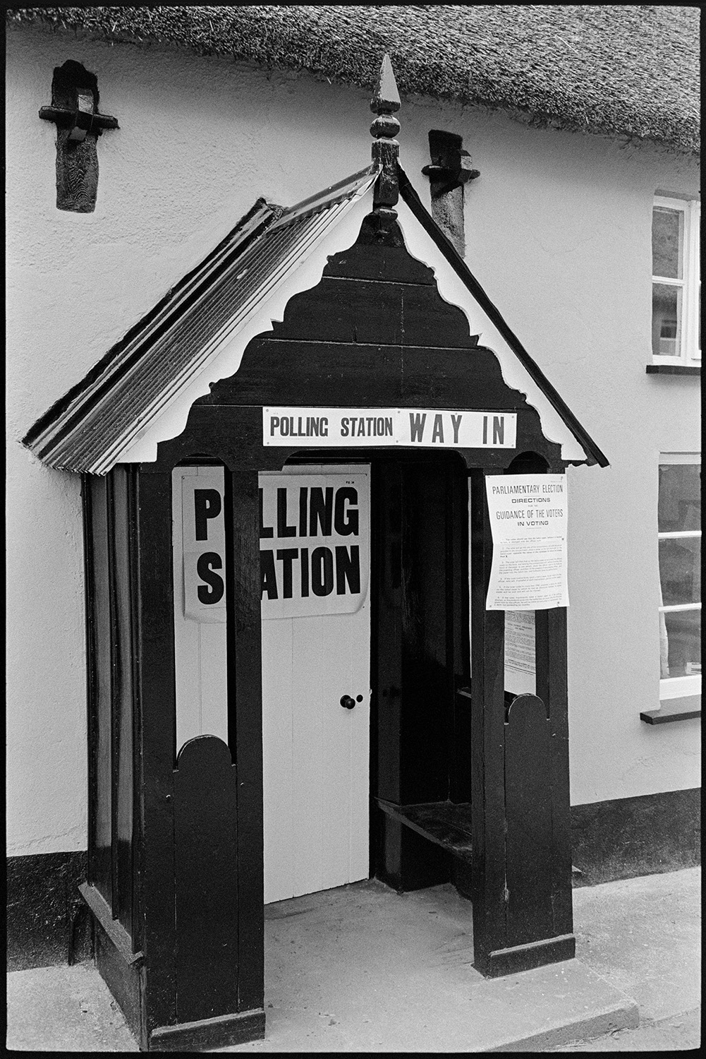Notices on village polling station.
[A thatched cottage with a 'Polling Station' poster and notice on the porch, at Monkokehampton.]