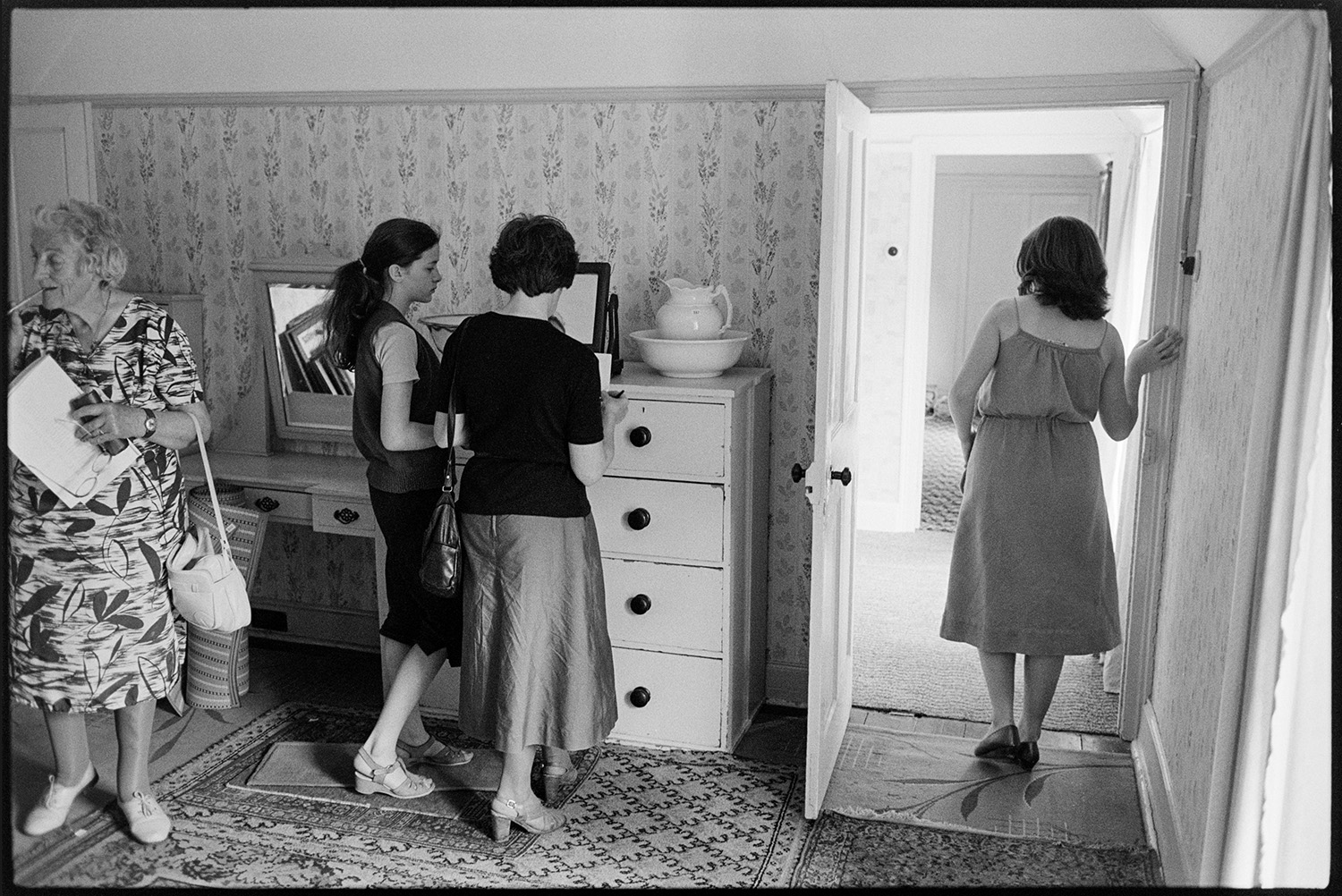Women looking at furniture, including a dressing table and chest of drawers, at Arscotts House, Dolton, on the viewing day before the contents of the house are sold.
