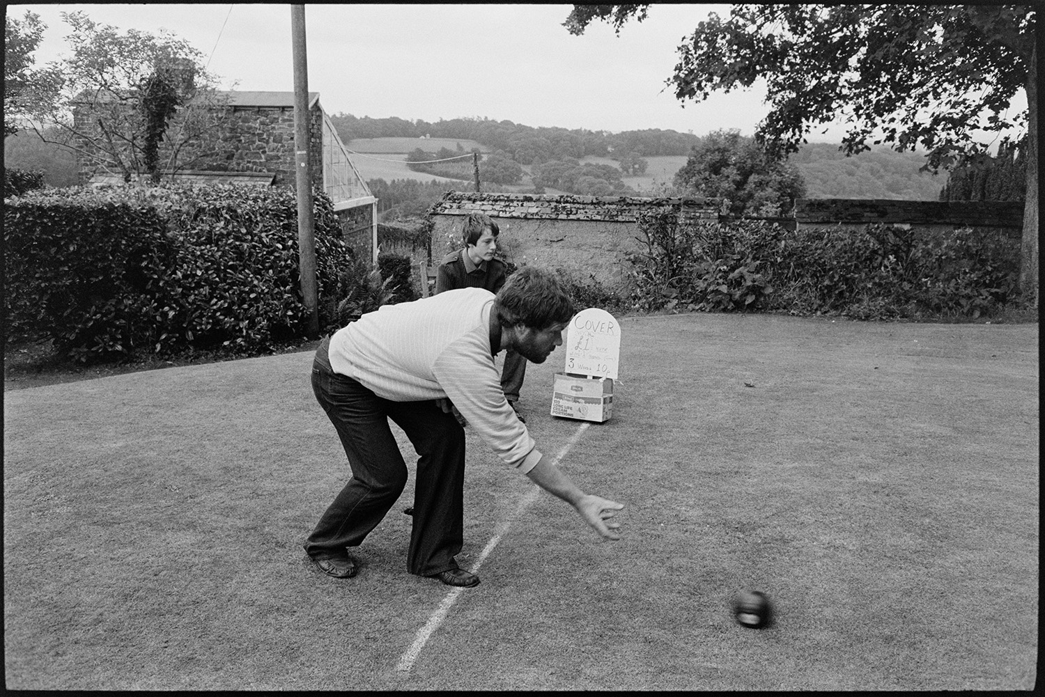 Swimming and sports at fete.
[Man playing boules during a fete at Merton Rectory.]