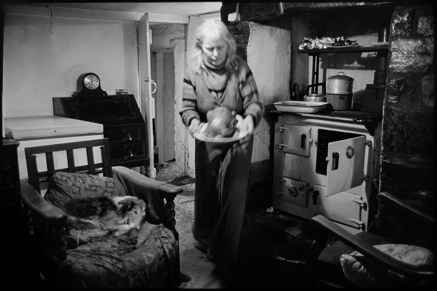 Waiting for Christmas dinner. Woman cooking turkey. Rayburn stove, carving turkey, eating. 
[Jo Curzon taking a roast turkey out of a rayburn oven and taking it to be carved at Horseshoe Cottage, Dolton for dinner on Christmas Day. A dog is sat on a chair by the rayburn.]