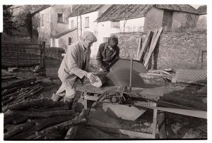 Alf Pugsley cutting logs on a circular saw by James Ravilious