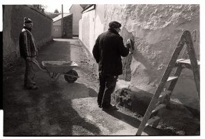 Derek Marden and Clifford Palmer repairing a cob wall by James Ravilious