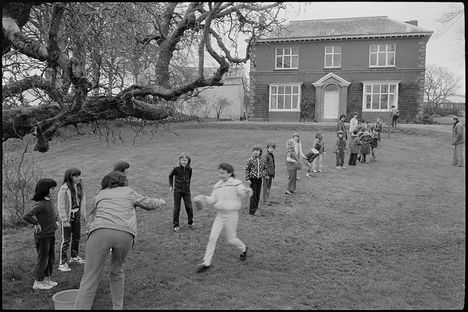 Children playing. Arts Centre. 
[Children playing a game on the lawn in front of the Beaford Centre at Greenwarren House, Beaford.]
